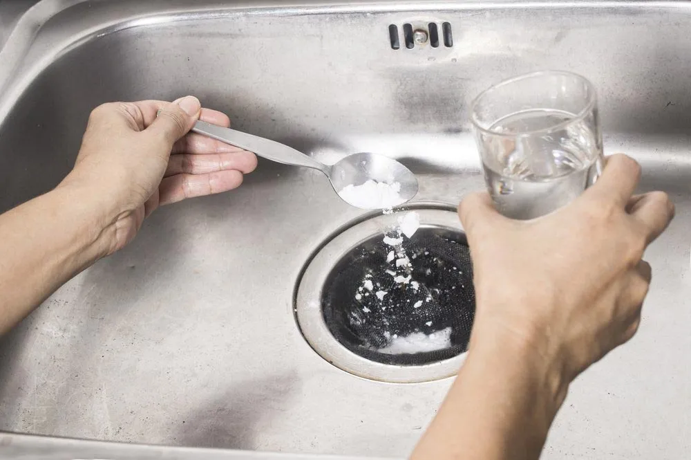 pouring baking soda and vinegar to blocked drain 1920w